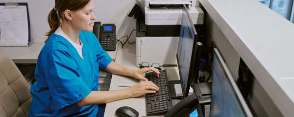 Une aide soignante saisie des informations à l'ordinateur